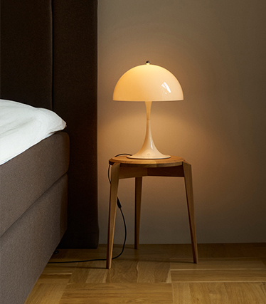 Lampe de chevet en forme de champignon diffusant une lumière délicate dans une chambre chaleureuse