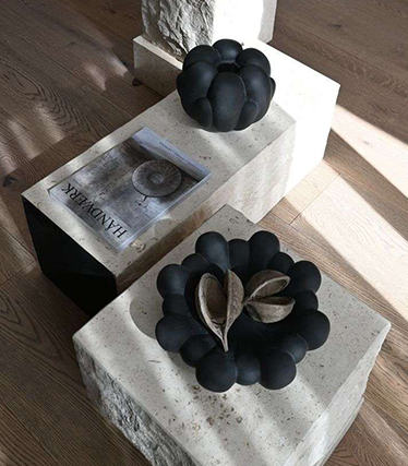 Bols en céramique noire artistique disposés sur des tables en pierre minimalistes