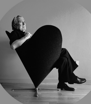 Verner Panton, installé dans un fauteuil sculptural, est mis en scène de façon iconique dans une esthétique monochrome et minimaliste.