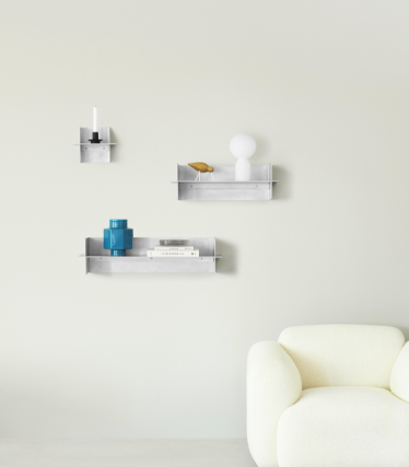 Étagères murales transparentes Normann Copenhagen avec accessoires décoratifs dans un espace de vie minimaliste.