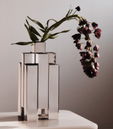 Vase sculptural en acier inoxydable poli de Ferm Living avec des fleurs rouge foncé