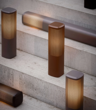 Luminaires d'extérieur Nordlux avec abat-jour perforés aux tons bruns et rouille sur des marches en béton