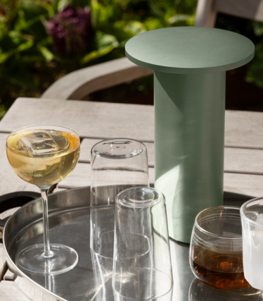 Table d’appoint/refroidisseur cylindrique vert sauge sur un plateau avec verres et boissons en extérieur.